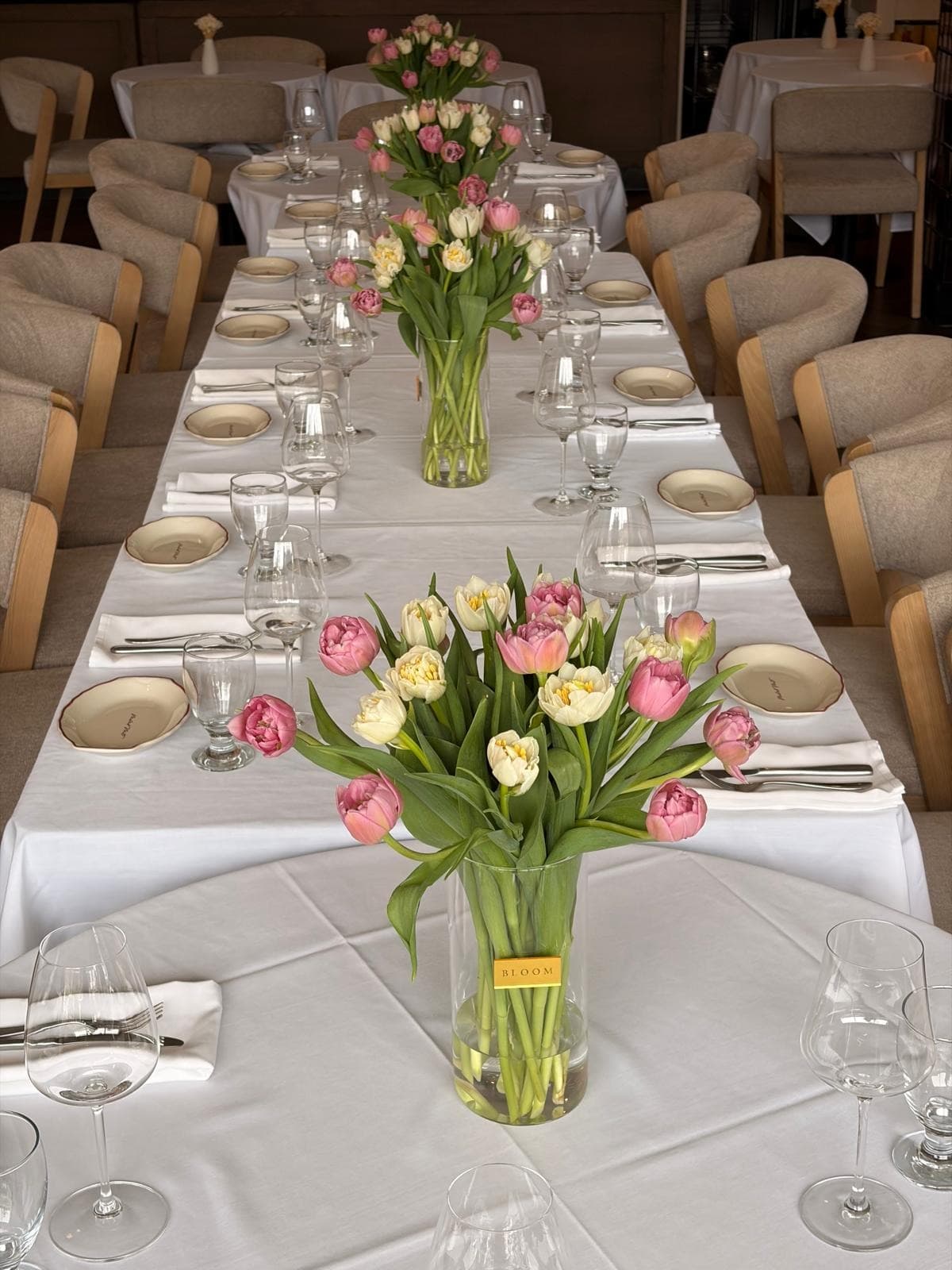 A long private dining table set with tulip arrangements
